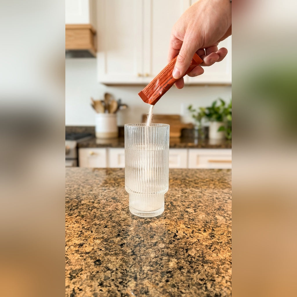 Pouring a SUOLAA electrolyte stick pack into a glass of water